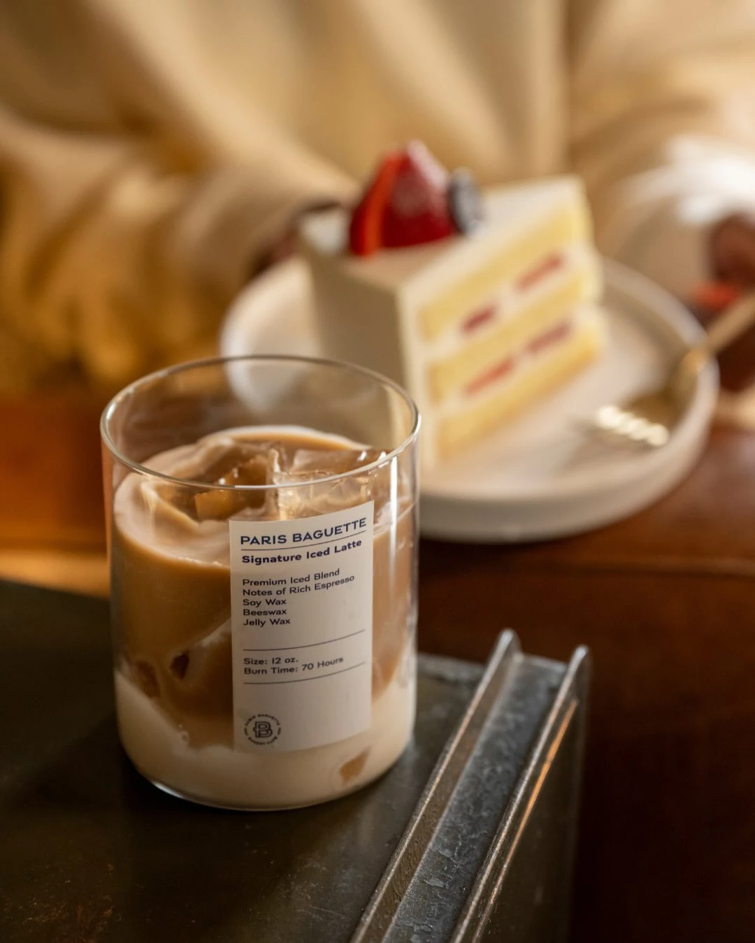 Paris Baguette iced-latte candle styled in a glass vessel with a product-label graphic and coffee-colored wax.